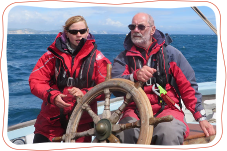 Man with dementia being helped to steer a sail boat