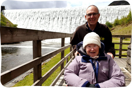 Lady in a wheelchair with a volunteern near a waterfall in Wales