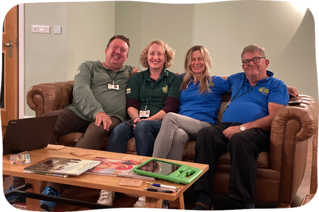 Volunteers on a Dementia Adventure holiday sitting on a sofa together
